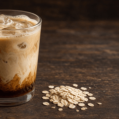 Foto es kopi susu aren berlapis dengan es batu, di samping taburan oat, meja kayu gelap